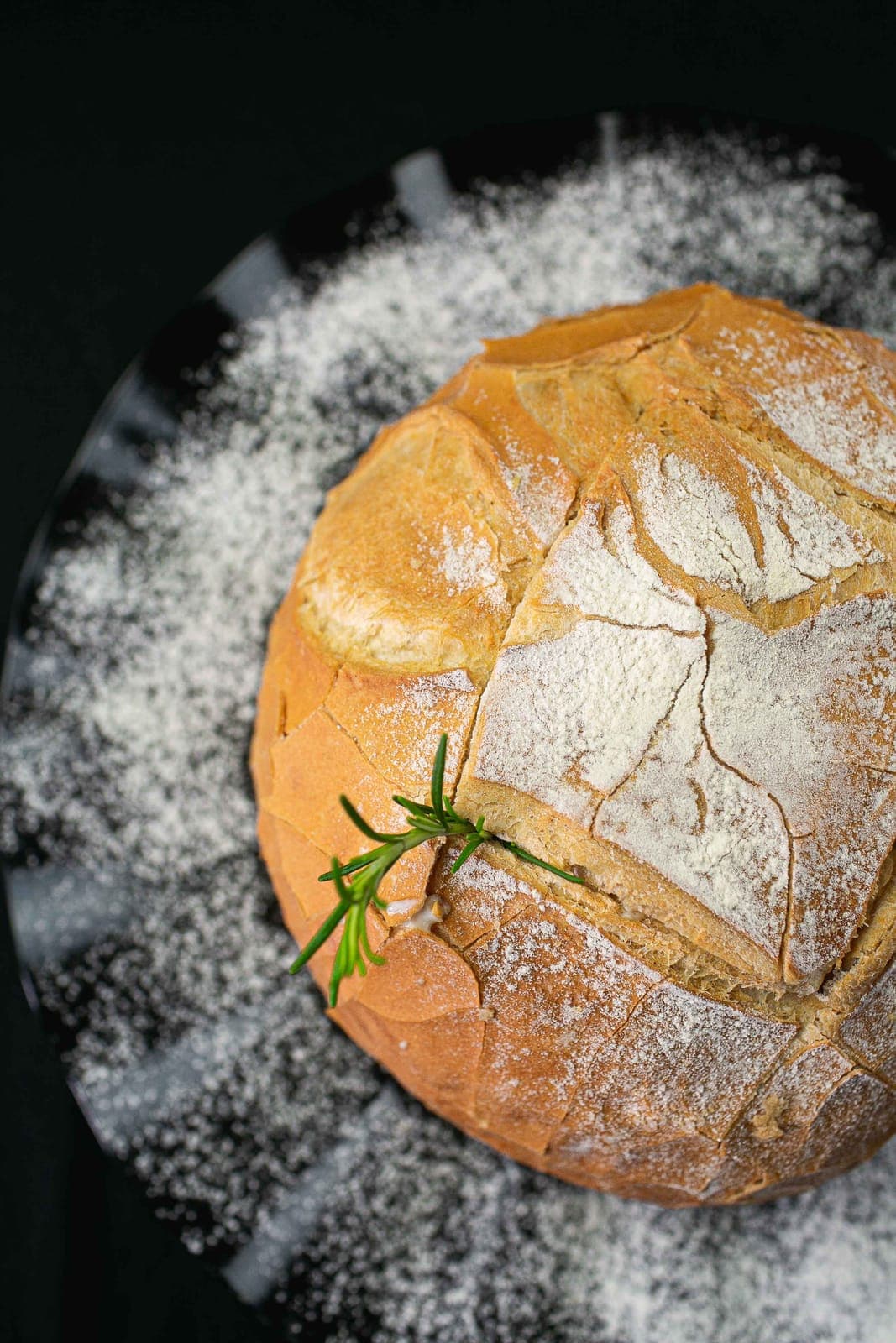 Pão artesanal rústico enfarinhado com um ramo de alecrim