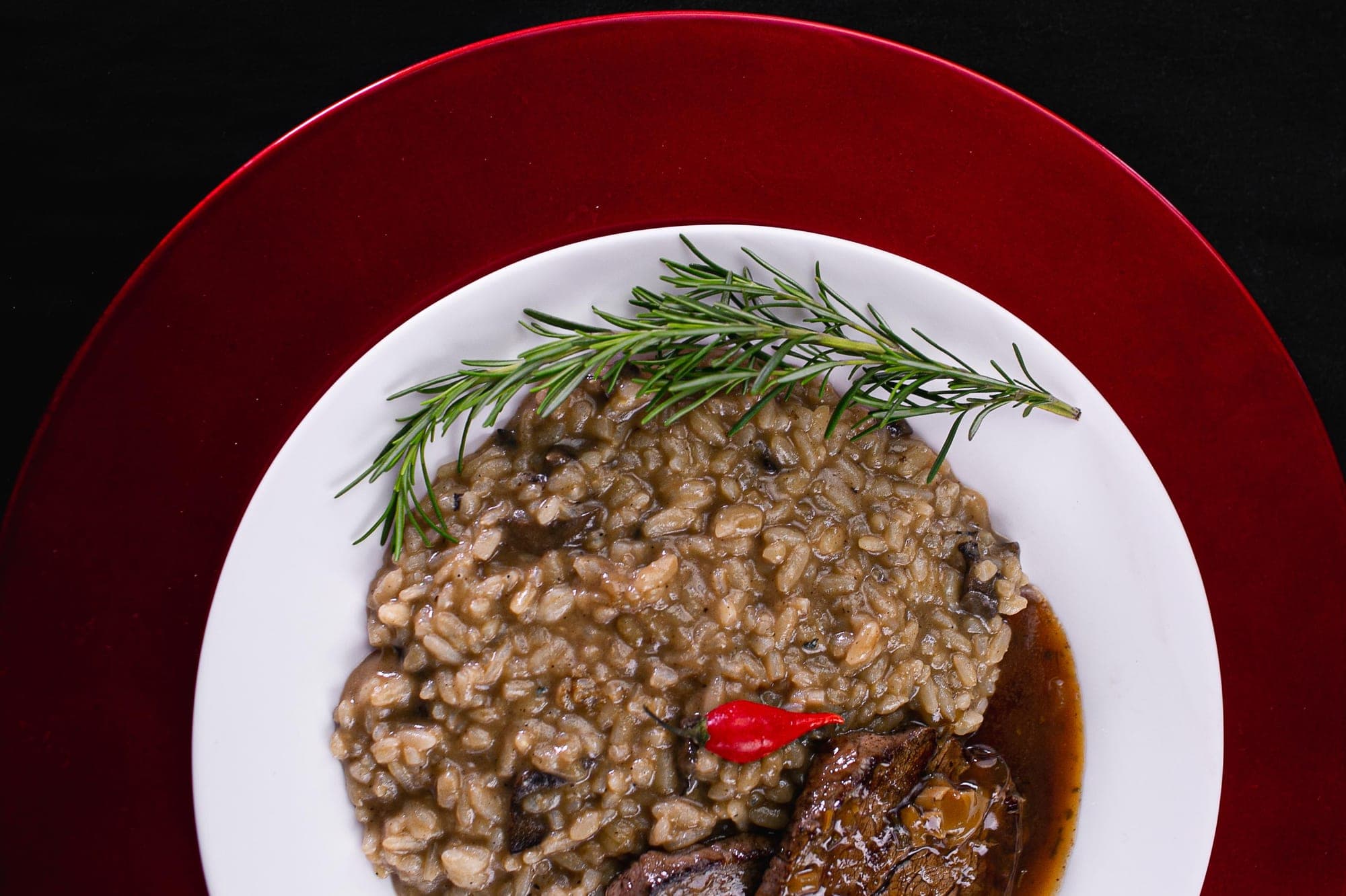 Risoto cremoso de cogumelos com medalhão de carne ao molho, pimenta-dedo-de-moça e alecrim